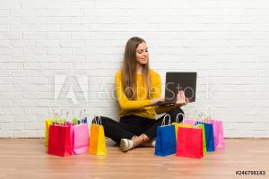 Young girl with lot of shopping bags with laptop